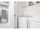 Well-lit laundry room with modern washer and dryer, and storage shelves for convenience at 2005 Nitsa St, Johns Island, SC 29455
