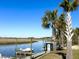 Scenic waterfront view with a private boat dock along the peaceful river surrounded by palm trees at 2014 Codorus Ln, Hanahan, SC 29410