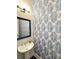 Stylish powder room with eye-catching wallpaper, modern fixtures, and a framed mirror at 2014 Codorus Ln, Hanahan, SC 29410