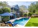 Enjoy the outdoor with a refreshing pool, sun loungers, manicured lawn, and a firepit at 2664 Magnolia Woods Dr, Mount Pleasant, SC 29464