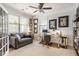 Bright home office with a comfortable gray sofa, multiple windows, and an organized workspace at 2664 Magnolia Woods Dr, Mount Pleasant, SC 29464