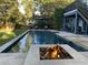 Backyard oasis with a sparkling pool, a stylish fire pit, and lush green lawn perfect for leisure at 2664 Magnolia Woods Dr, Mount Pleasant, SC 29464