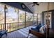 Spacious screened porch featuring a hanging swing bed, ceiling fan, and views of the surrounding landscape at 2664 Magnolia Woods Dr, Mount Pleasant, SC 29464