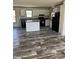 Modern kitchen featuring sleek black appliances, stylish wood-look flooring, and bright white cabinets with plenty of counter space at 286 Marion Rd, Dorchester, SC 29437