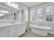 Bathroom featuring a sink and cabinet, standalone soaking tub, and plantation shutters at 2876 Rivertowne Pkwy, Mount Pleasant, SC 29466