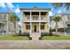 Inviting yellow two-story home featuring double porches and meticulously maintained landscaping at 2876 Rivertowne Pkwy, Mount Pleasant, SC 29466