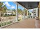 Spacious covered porch showcasing wood flooring and white railing with neighborhood views at 2876 Rivertowne Pkwy, Mount Pleasant, SC 29466