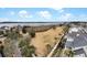 Aerial view of waterfront property with a grassy area, palm trees, and upscale homes in the background at 2876 Rivertowne Pkwy, Mount Pleasant, SC 29466