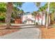 Charming two-story home with pink siding, lush palm trees, and a winding gravel driveway at 3 25Th Ave, Isle of Palms, SC 29451