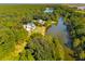 Stunning aerial view of lush property featuring two homes along a serene river, surrounded by trees and greenery at 4105 Gnarled Oaks Ln, Johns Island, SC 29455