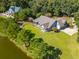 Aerial view of a beautiful blue house surrounded by lush greenery and a picturesque pond at 4105 Gnarled Oaks Ln, Johns Island, SC 29455