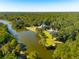 Breathtaking aerial view of a beautiful home nestled among trees on a lake at 4105 Gnarled Oaks Ln, Johns Island, SC 29455