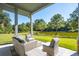 Relax on the back porch with comfortable seating and stunning views of the lush backyard at 4105 Gnarled Oaks Ln, Johns Island, SC 29455