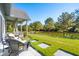 Inviting back porch with wicker furniture overlooks a lush lawn and serene lake at 4105 Gnarled Oaks Ln, Johns Island, SC 29455