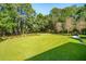 Lush green backyard featuring mature trees and a manicured lawn at 4105 Gnarled Oaks Ln, Johns Island, SC 29455