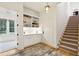 Bright entryway with built-in shelving, a staircase, wood floors, and a view into a sunroom at 4105 Gnarled Oaks Ln, Johns Island, SC 29455