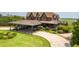 Grand clubhouse featuring covered parking for golf carts, lush landscaping, and picturesque curb appeal at 4105 Gnarled Oaks Ln, Johns Island, SC 29455