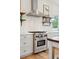 Gourmet kitchen featuring a Wolf range, stylish hood, and floating shelves at 4105 Gnarled Oaks Ln, Johns Island, SC 29455