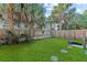 Private backyard is fenced in and features a lush lawn and mature palm trees at 47 Drake St, Charleston, SC 29403