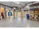 Spacious basement with blue epoxy floors, blue cabinets and multiple garage doors at 4935 Sound View Dr, Mount Pleasant, SC 29466