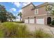 Three-car garage with a large driveway and beautifully landscaped front yard at 4935 Sound View Dr, Mount Pleasant, SC 29466