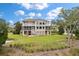 Expansive three-story home overlooking lush green yard and serene pond at 4935 Sound View Dr, Mount Pleasant, SC 29466
