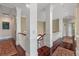 Elegant upstairs hallway featuring hardwood floors, white columns, and a view of the staircase at 4935 Sound View Dr, Mount Pleasant, SC 29466
