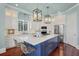 Spacious kitchen with white cabinets, a blue island with seating, and modern pendant lighting at 4935 Sound View Dr, Mount Pleasant, SC 29466