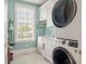 Efficient laundry room featuring modern, stacked washer and dryer, and convenient sink area with white cabinets at 4935 Sound View Dr, Mount Pleasant, SC 29466