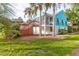 Backyard showcasing lush green lawn and mature palm trees surrounding the quaint blue home at 5 25Th Ave, Isle of Palms, SC 29451