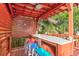 Close-up of outdoor covered bar with marble countertop, four colorful stools, and charming fish decor at 5 25Th Ave, Isle of Palms, SC 29451