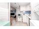 Cozy kitchenette with white cabinetry, blue backsplash, and modern appliances adjacent to the living area at 5 25Th Ave, Isle of Palms, SC 29451