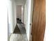 Hallway with wood floor and white walls leading to bedroom with carpet at 5056 Butler St, North Charleston, SC 29406