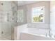 Updated bathroom with large tub, white tile, and glass shower at 506 Cecilia Cove Dr, Charleston, SC 29412