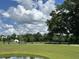 Serene community landscape with lush green lawns, mature trees, and a tranquil pond reflecting the sky at 5122 Double Eagle, Summerville, SC 29485