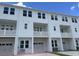 Modern white townhome boasts a pristine facade, multiple windows, private balconies and convenient garage access at 5122 Double Eagle, Summerville, SC 29485