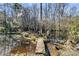 Picturesque pond reflecting surrounding trees, with a rustic dock and calm water at 5219 Maybank Hwy, Wadmalaw Island, SC 29487