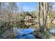 Scenic view of a cabin reflected in the tranquil waters of a pond, surrounded by lush greenery at 5219 Maybank Hwy, Wadmalaw Island, SC 29487