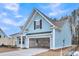 Beautiful, light blue home features an attached two-car garage, a covered porch, and a gabled roof at 429 Grove End Rd, Moncks Corner, SC 29461