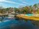 Picturesque aerial view of a community pool and clubhouse next to a serene pond with a fountain at 7930 Timbercreek Ln # C, North Charleston, SC 29418