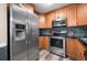 Well-lit kitchen showcasing stainless steel appliances, wood cabinets, black countertops, and modern backsplash at 7930 Timbercreek Ln # C, North Charleston, SC 29418