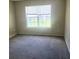 Spacious bedroom with neutral carpet and a large window providing natural light at 7963 Weld St, North Charleston, SC 29418