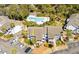 Aerial view of condo with parking and a pool surrounded by lush green trees at 8 Lagoon Villas, Isle of Palms, SC 29451