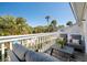 Relaxing balcony seating with gray cushions and table overlooking lush green foliage at 8 Lagoon Villas, Isle of Palms, SC 29451