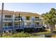 An exterior view shows a charming two-story condo building with balconies and lush landscaping at 8 Lagoon Villas, Isle of Palms, SC 29451