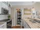Bright kitchen with white cabinetry, modern appliances, marble counters, and convenient pantry access at 8 Lagoon Villas, Isle of Palms, SC 29451