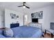Inviting bedroom with blue bedding, dresser with TV, ceiling fan, and neutral colored chair at 87 Ashley Hall Plantation Rd # 108, Charleston, SC 29407