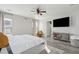 Well-lit bedroom with a large bed, ceiling fan, TV, and a cozy chair with throw at 8816 Kellum Dr, North Charleston, SC 29420