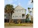 Two-story gray home with a black fence and a yellow fire hydrant in the front yard at 9 J C Long Blvd, Isle of Palms, SC 29451