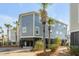 Coastal home featuring a raised foundation, blue siding, and palm trees adding a touch of tropical charm at 9 J C Long Blvd, Isle of Palms, SC 29451